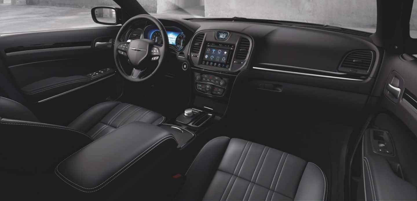 Display The interior of the 2023 Chrysler 300 focusing on the front seats, steering wheel, touchscreen and dashboard.