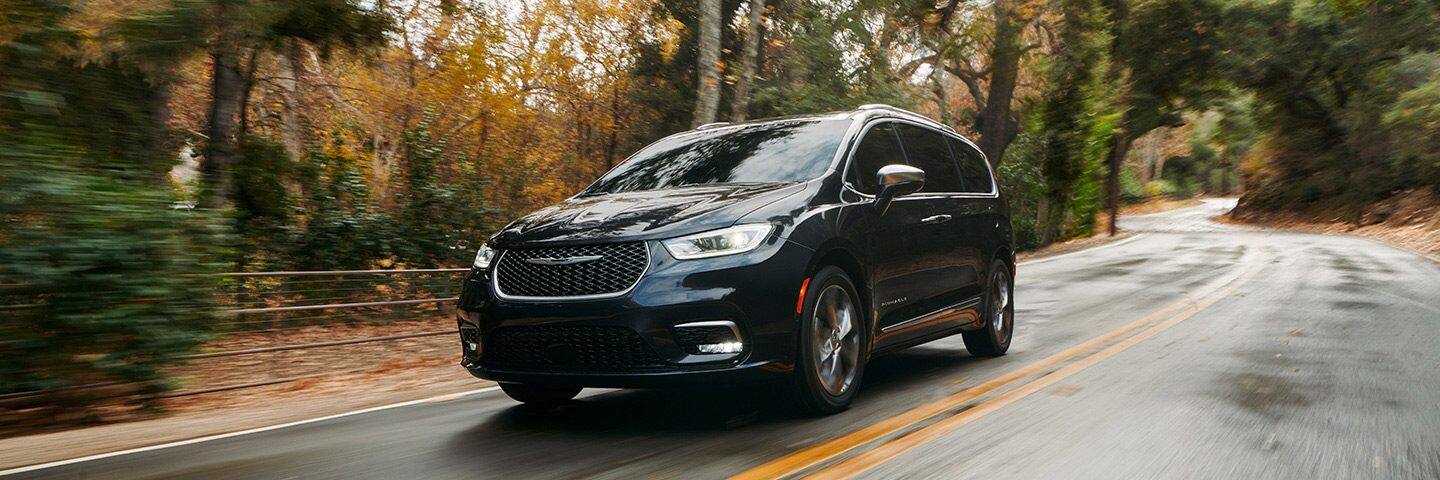 The 2022 Chrysler Pacifica Pinnacle being driven on a two-lane road with the scenery blurred to indicate its speed.
