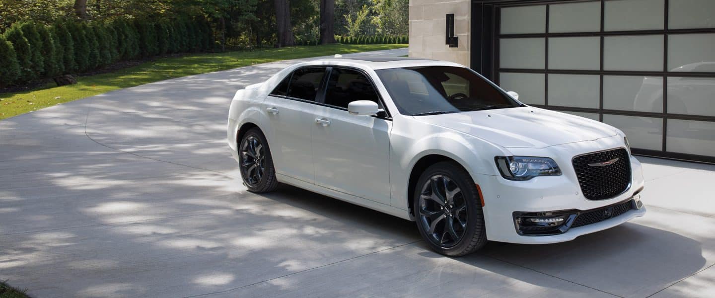 El Chrysler 300S 2023 estacionado en una entrada de un hogar moderno y elegante