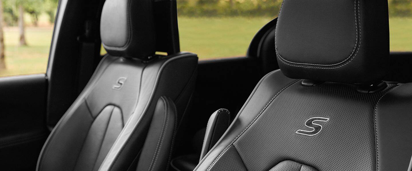 Una imagen deslizable que, cuando se corre hacia la derecha, revela el asiento del conductor en la Chrysler Pacifica TBD Hybrid 2023 con el paquete de apariencia S y que, cuando se corre hacia la izquierda, revela el asiento del conductor en la Chrysler Pacifica Pinnacle Hybrid 2023.