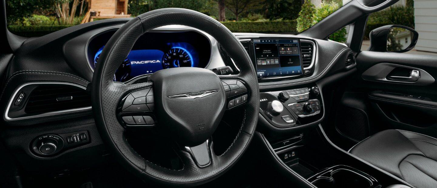 El interior de la Chrysler Pacifica TBD Hybrid 2023 que se centra en el volante, la pantalla digital en el panel de instrumentos y la pantalla táctil Uconnect.