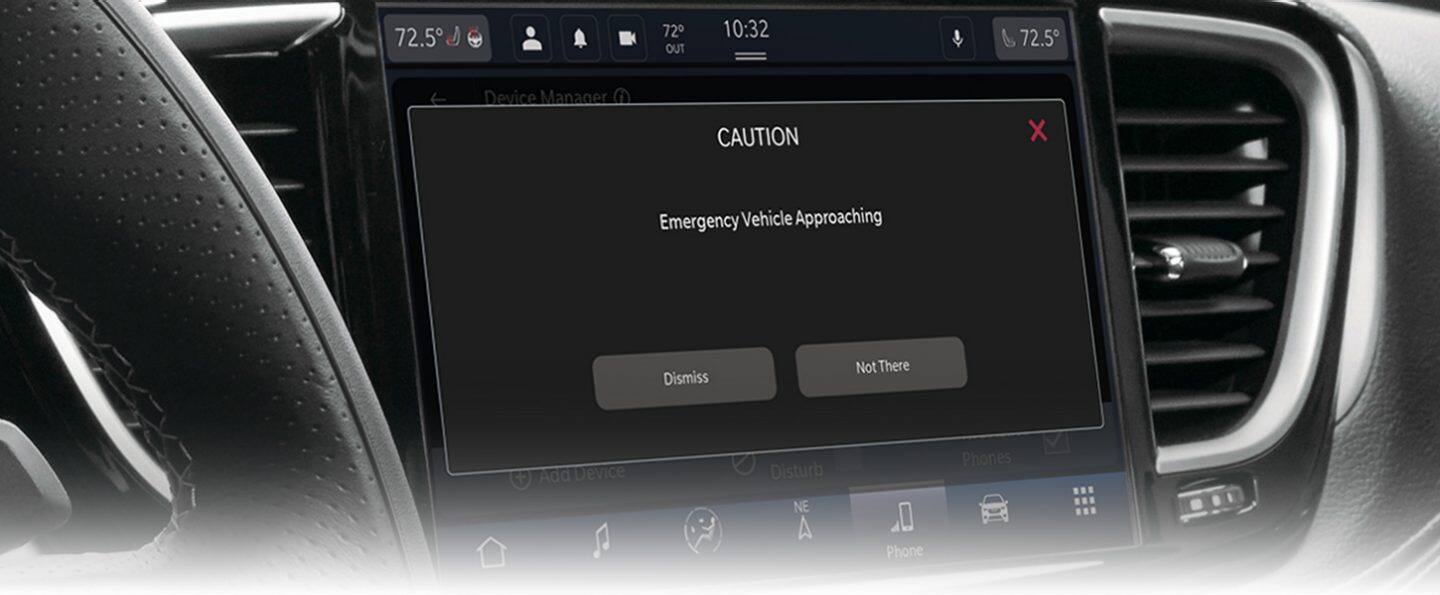 The Uconnect touchscreen in the 2024 Chrysler Pacifica Plug-In Hybrid displaying the emergency vehicle approaching alert.