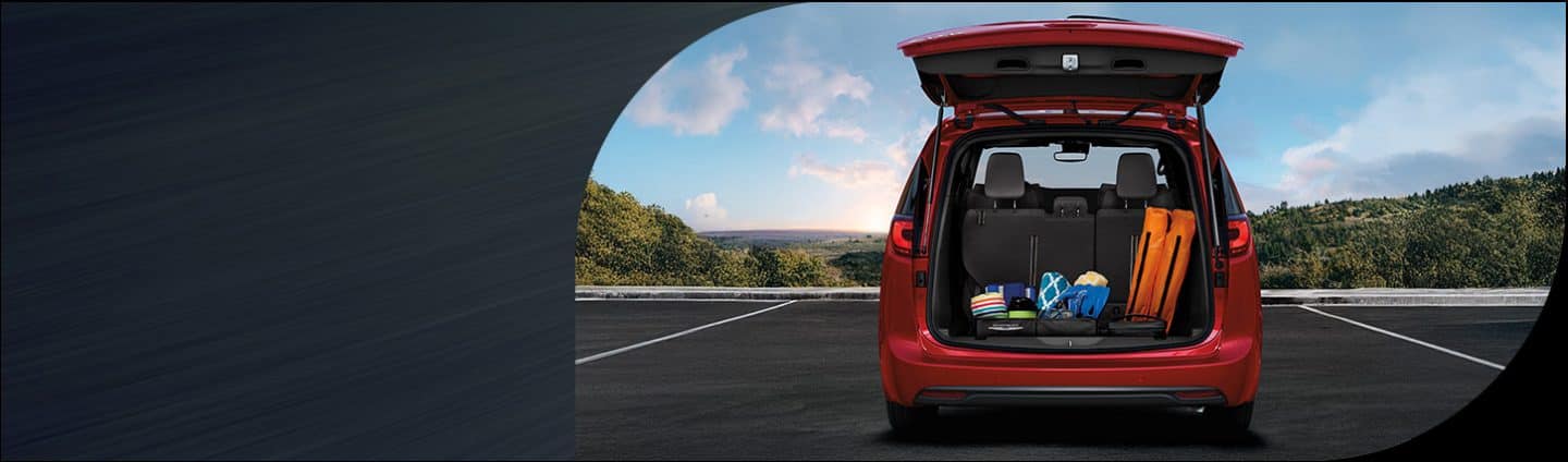 The rear of a red 2026 Chrysler Pacifica Limited with its liftgate open revealing cargo behind the third-row seats.