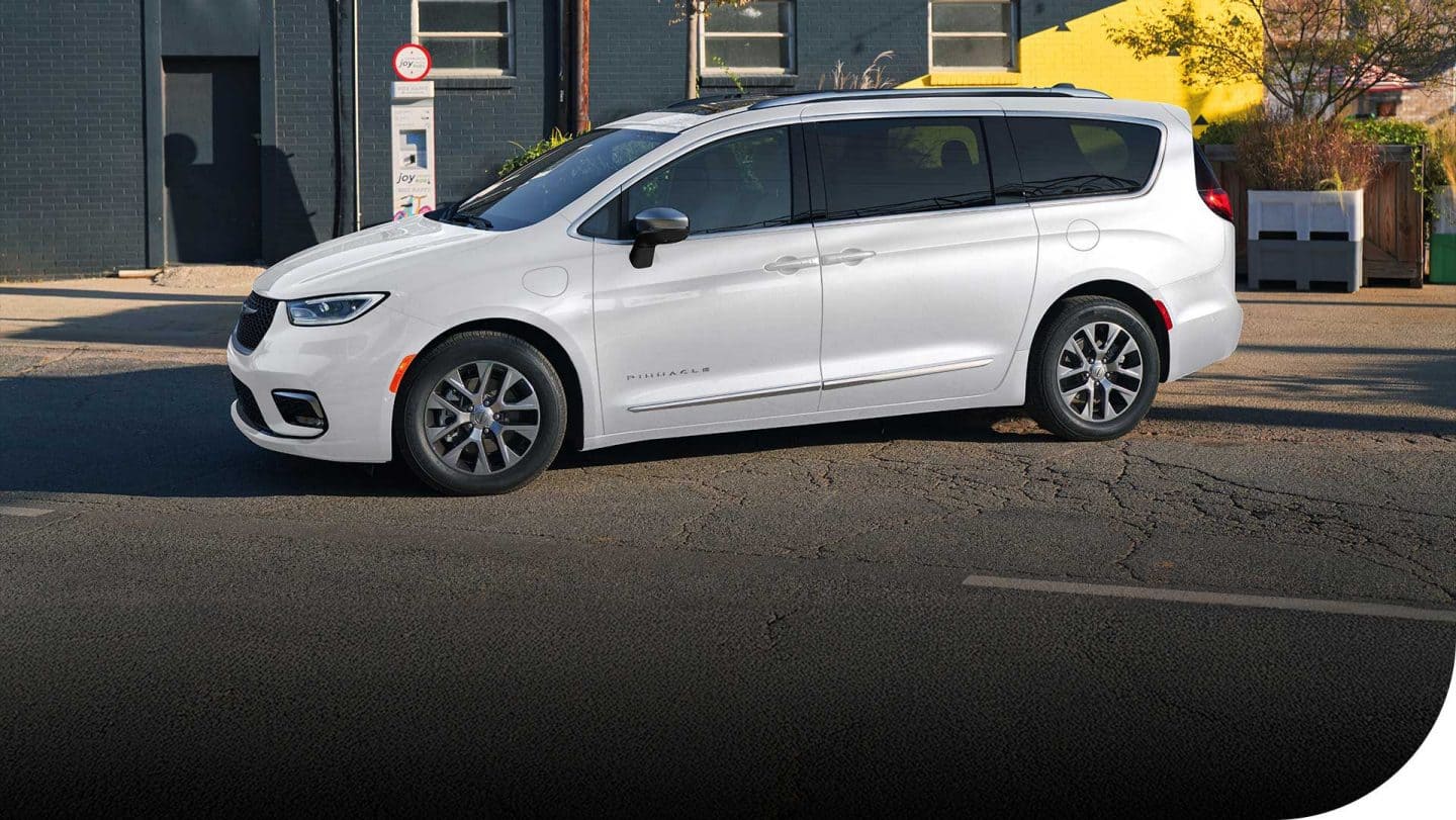 A driver-side profile of a white 2026 Chrysler Pacifica Plug-in Hybrid Pinnacle.