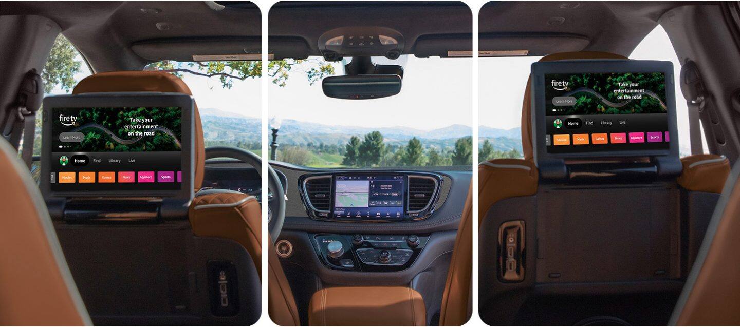 El interior de la Chrysler Pacifica Plug-in Hybrid Pinnacle 2026 desde una perspectiva de la tercera fila hacia adelante, con las dos pantallas táctiles montadas en los respaldos de los asientos en la segunda fila, en las que se exhiben selecciones de Amazon FireTV.