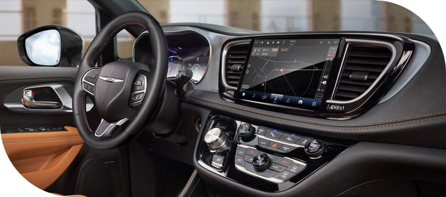 The front row in the 2026 Chrysler Pacifica Plug-in Hybrid Pinnacle, including the steering wheel, Digital Cluster Display, Uconnect touchscreen and center stack controls.