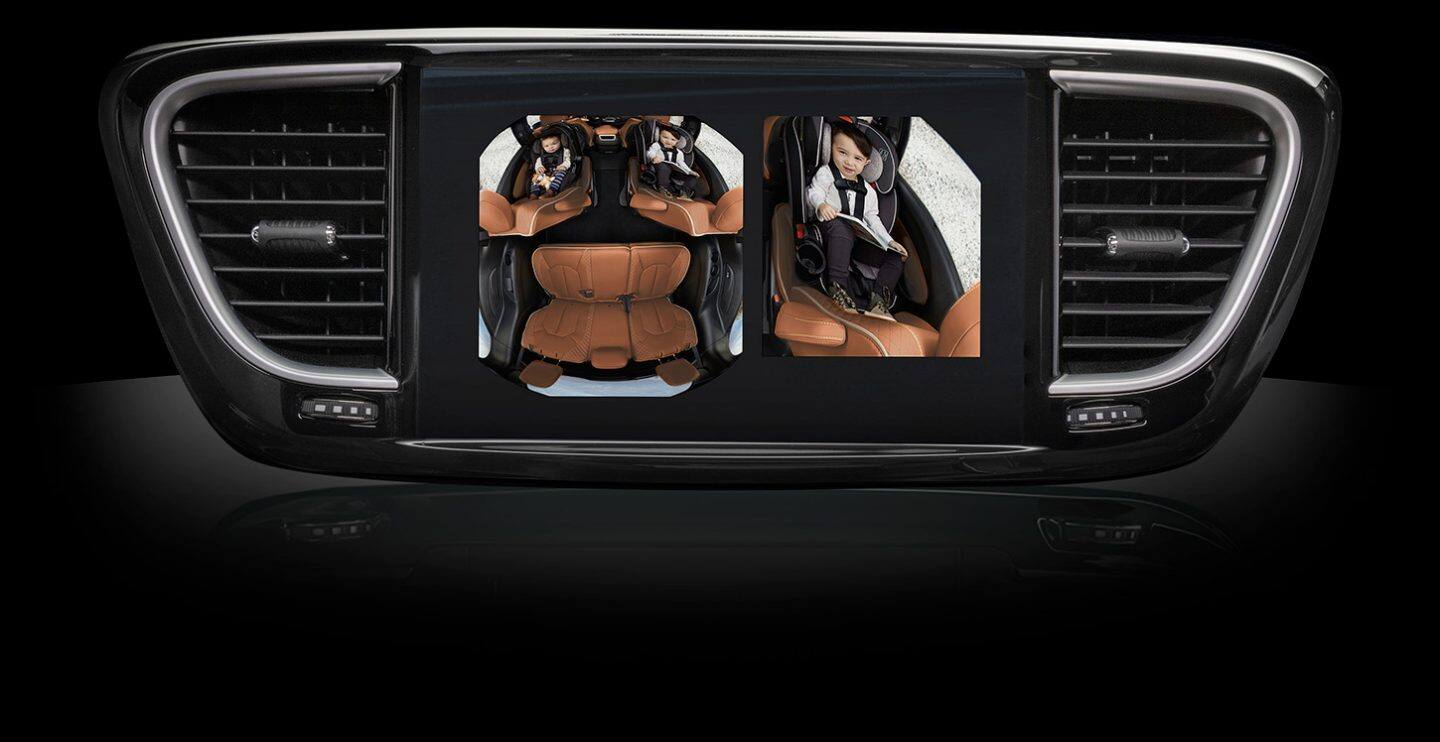 The Uconnect touchscreen in the 2026 Chrysler Pacifica displaying a split-screen from the FamCam of the children in the second-row seats.