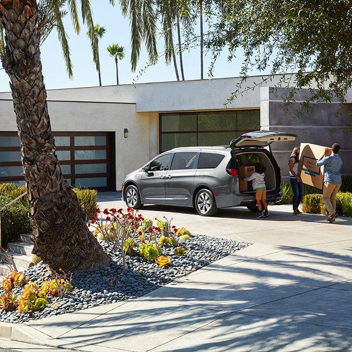2019 Chrysler Pacifica Hybrid Fuel Efficient Minivan People Unloading Items From A Chrysler Pacifica Hybrid Parked In Driveway