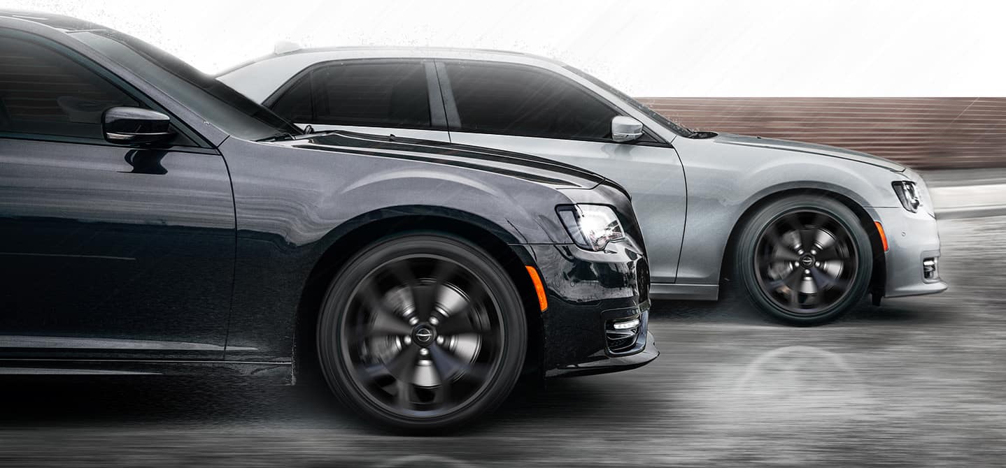 Two 2021 Chrysler 300S being driven side-by-side in the rain.
