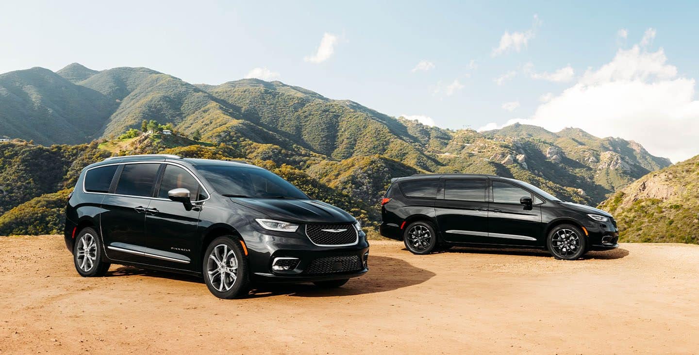 Display The 2021 Chrysler Pacifica Pinnacle and Pacifica Limited with the available S Appearance Package parked on a sandy hill in the mountains.