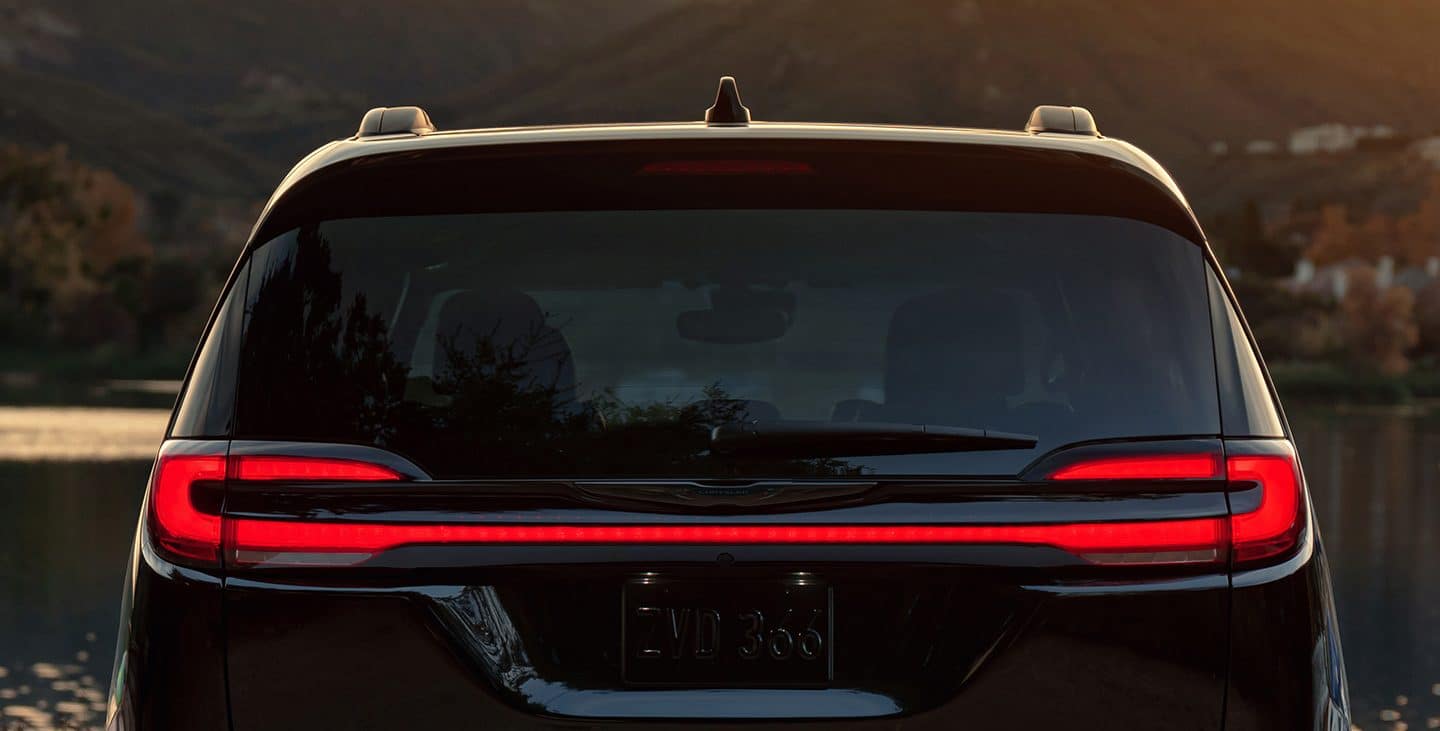Display The red taillamps on the 2021 Chrysler Pacifica, lit up at dusk.