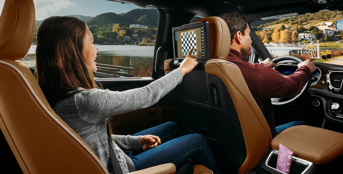Display A passenger in the second row of the 2021 Chrysler Pacifica Pinnacle playing chess on the seatback touchscreen.