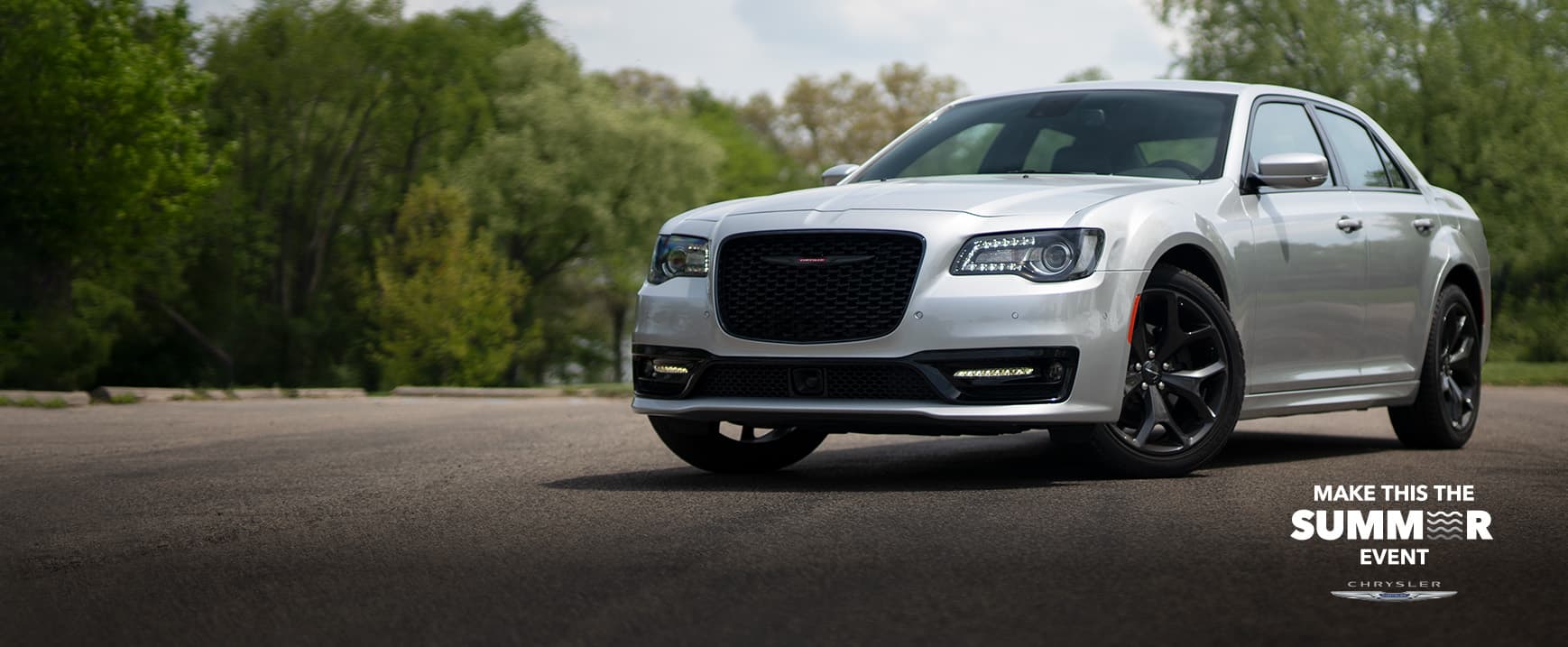 An angled driver-side profile of a silver 2023 Chrysler 300S. Make this the Summer Event logo.