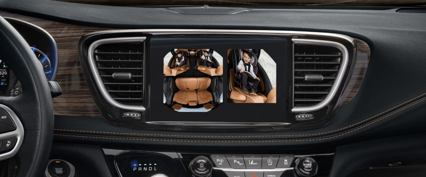 A close-up of the Uconnect touchscreen in the 2023 Chrysler Pacifica Hybrid displaying the split screen images of the second- and third-row seats from the interior FamCam camera.