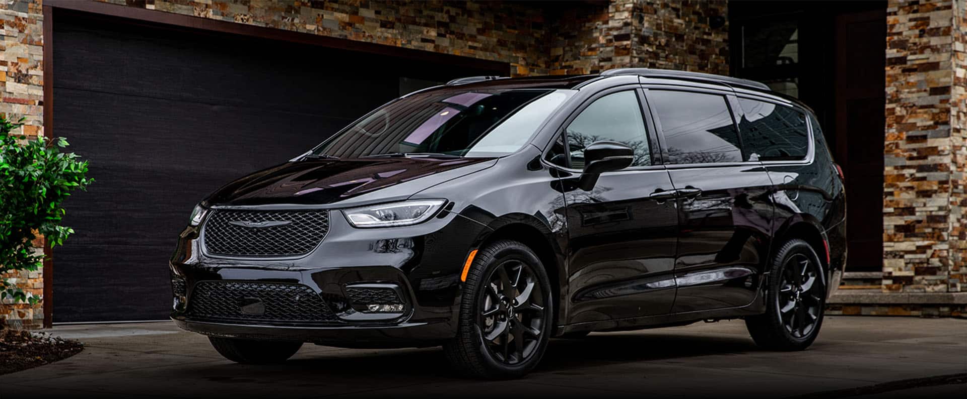 An angled driver-side profile of a black 2024 Chrysler Pacifica Limited with S Appearance Package