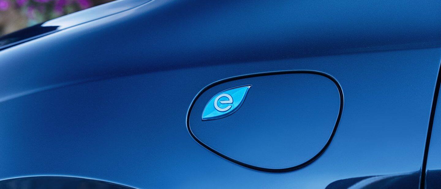 Display A close-up of the charging port cover on the 2024 Chrysler Pacifica Pinnacle Plug-In Hybrid.