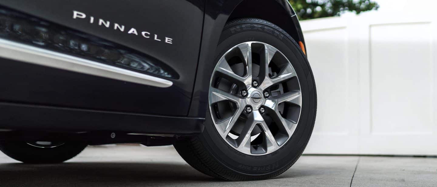 Display The wheel and tire on a black 2025 Chrysler Pacifica Pinnacle Plug-in Hybrid.
