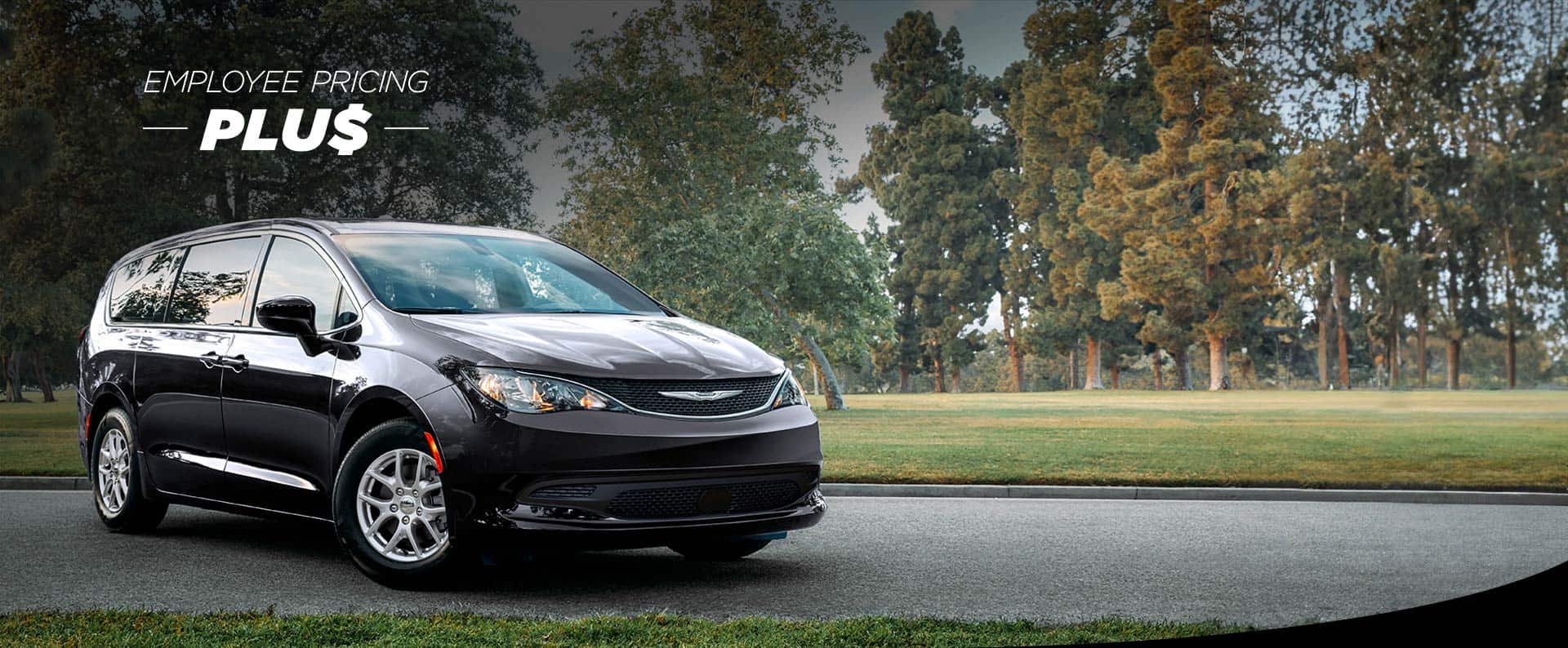 A front pasengers side view of a black 2025 Chrysler Voyager LX in a parking lot of a park. Employee Pricing Plus sales event.