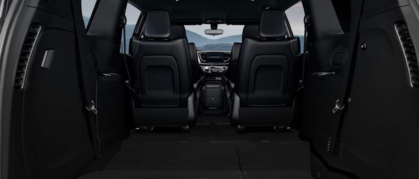 Display The front- and second-row seats in the 2025 Chrysler Voyager LX, from the rear, to the front, with the third-row seats folded into the floor.