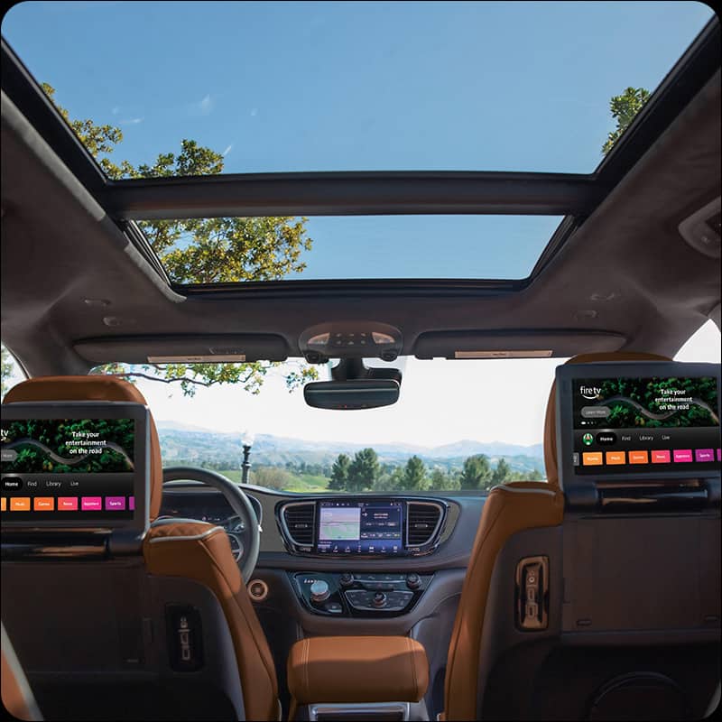 The interior of the 2026 Chrysler Pacifica from the rear of the vehicle, with a couple in the front seats, a child in the driver-side second-row seat, a child in the driver-side third-row seat and cargo on the passenger-side second- and third-row.