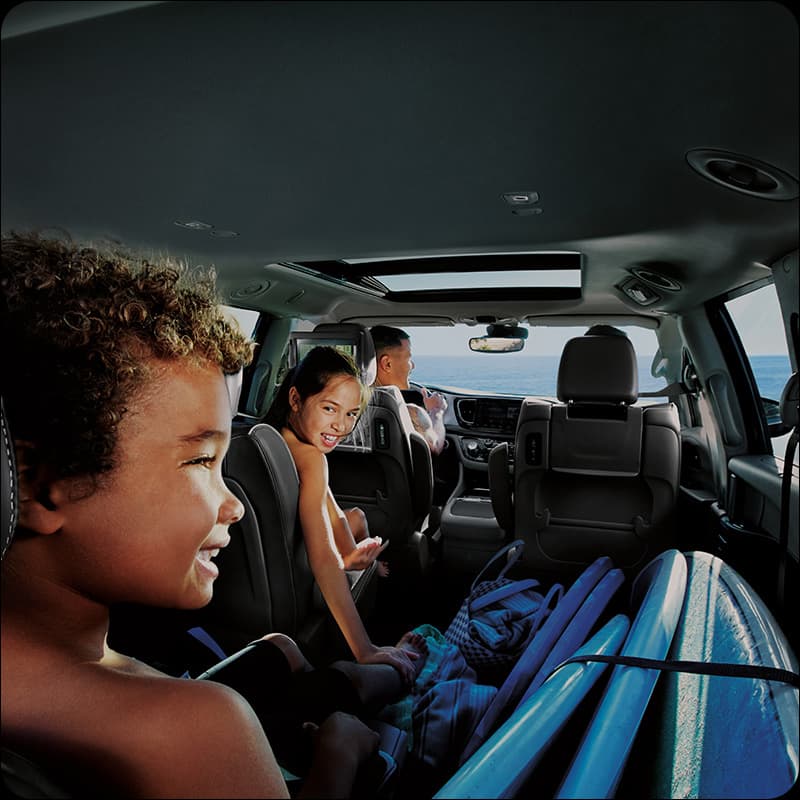 On the left, a red 2026 Chrysler Pacifica and on the right a gray 2026 Chrysler Pacifica parked next to each other.