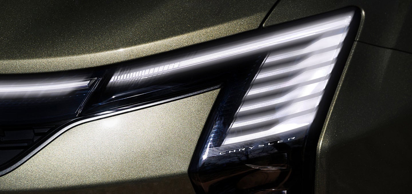 The front end of a olive green 2027 Chrysler Pacifica Pinnacle.
