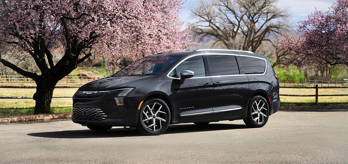 A black 2027 Chrysler Pacifica Pinnacle at a park.
