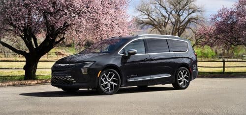 A black 2027 Chrysler Pacifica Pinnacle at a park.