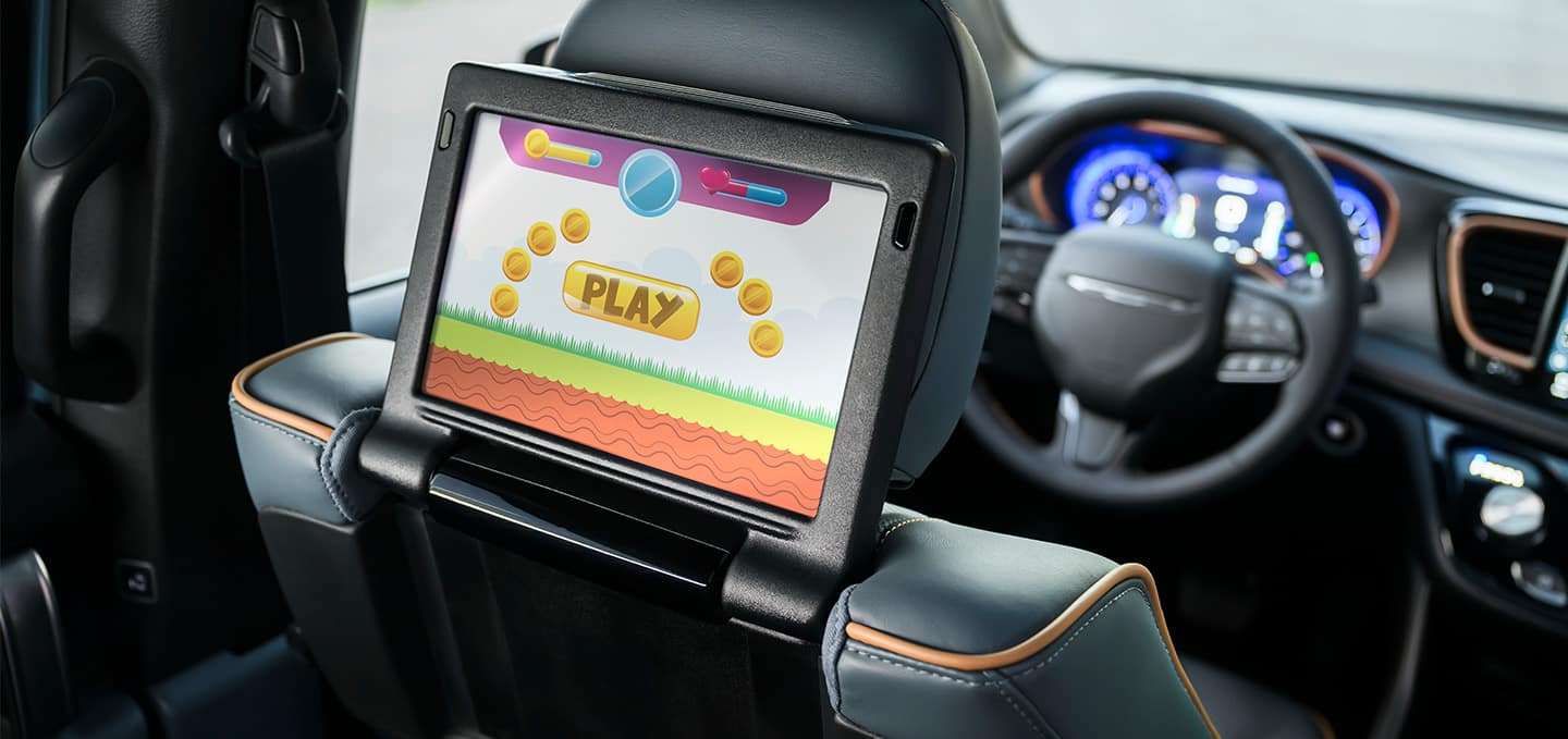 The 2027 Chrysler Pacifica Pinnacle focusing on the driver-side seatback-mounted touchscreen for second-row passengers.