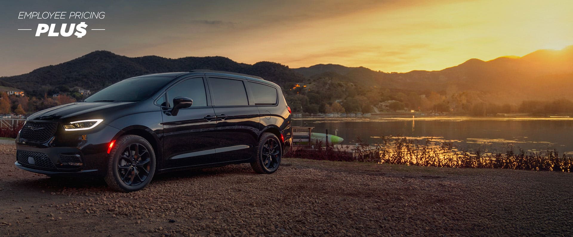A black 2025 Chrysler Pacifica Limited parked by a lake at sunset. Employee Pricing Plus sales event.