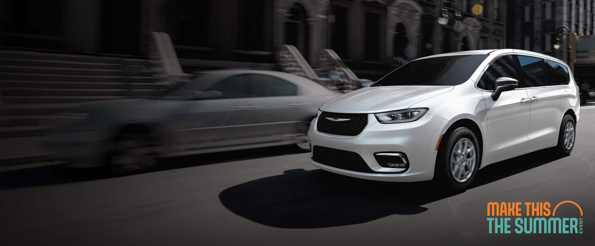 A white 2026 Chrysler Pacifica Select driving down a city street. Make this the Summer Sales Event.