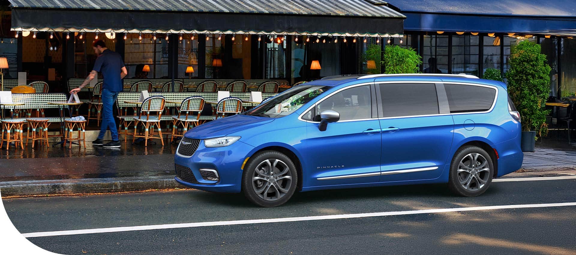 A blue 2026 Chrysler Pacifica Limited parked parked in front of a restaurant.
