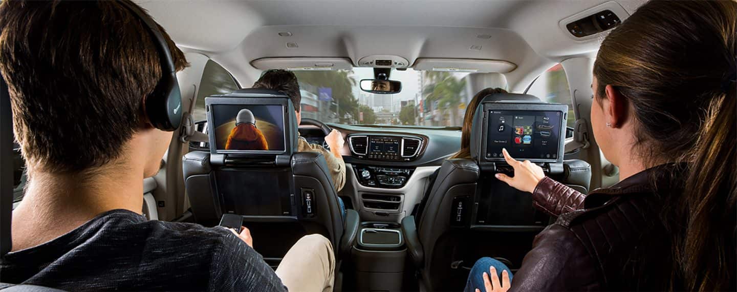 Two people using the Uconnect Theater in the second row of their vehicle.